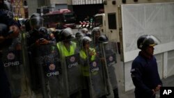 Elementos de la Policía Nacional Bolivariana enfrenta una marcha en la sede de la Oficina Nacional de Presupuesto (ONAPRE) en Caracas, Venezuela, el martes 23 de agosto de 2022.