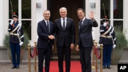 El secretario general de la OTAN, Jens Stoltenberg, a la izquierda, y el primer ministro holandés, Mark Rutte, a la derecha, dan la bienvenida al presidente de Lituania, Gitanas Nauseda, en La Haya, Países Bajos, el 27 de junio de 2023.