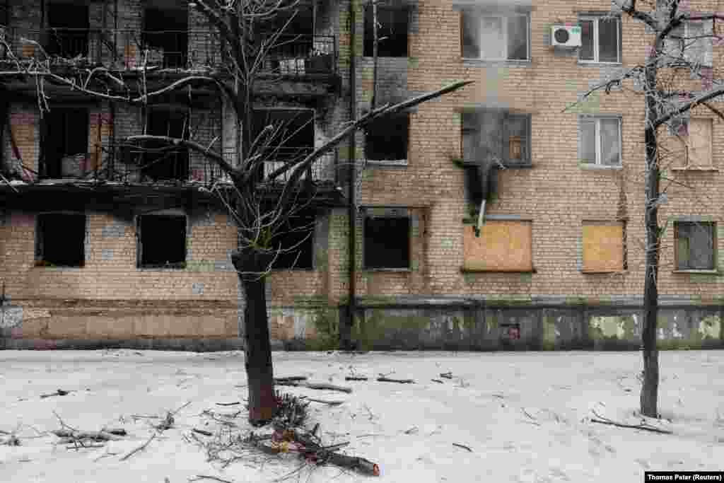 Un tubo de chimenea emite humo en el apartamento de Viktor Ivanovich, una de las pocas personas que permanecen en el edificio dañado.
