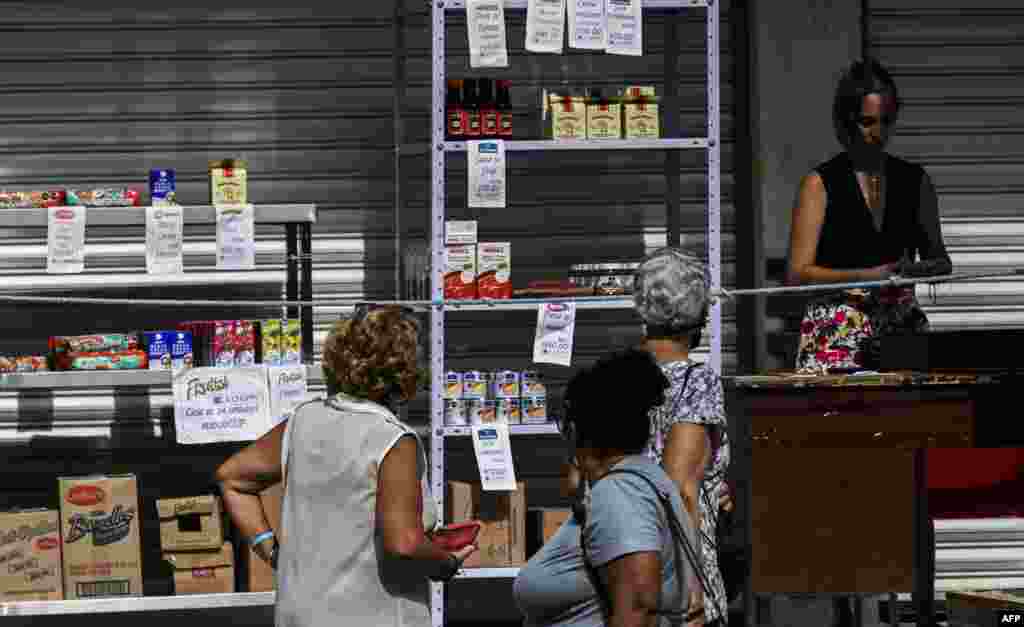 La gente observa precios y productos en un puesto de venta de un negocio particular en La Habana, Cuba, el 6 de junio de 2023.