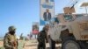 Des soldats de la paix ougandais de la Mission africaine de transition en Somalie (ATMIS) se tiennent à côté de leur véhicule blindé dans une rue de Mogadiscio, en Somalie, le 10 mai 2022.