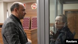 资料照片：被控违反俄罗斯“外国代理人”法的自由欧洲电台/自由电台记者阿尔苏·库尔玛舍娃在法庭听证上与律师交谈。（2023年10月23日）