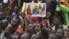 Un homme brandit une affiche réunissant la capitaine Traoré, le général Tiani et le colonel Goïta, les chefs militaires du Burkina Faso, du Niger et du Mali, lors d'une manifestation à Niamey en septembre 2023.