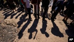 Los migrantes esperan ser procesados ​​por la Patrulla de Aduanas y Protección Fronteriza de EEUU después de cruzar el Río Grande y entrar a territorio estadounidense desde México, el 19 de octubre de 2023, en Eagle Pass, Texas.