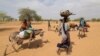 Sudanese families fleeing the conflict in Sudan's Darfur region make their way through the desert after they crossed the border between Sudan and Chad to seek refuge in Goungour, Chad, May 12, 2023.
