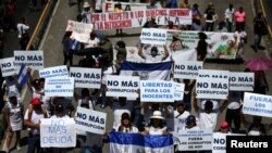 La gente participa en una protesta contra la reelección del presidente de El Salvador, Nayib Bukele, y contra la detención de personas inocentes durante el estado de emergencia del gobierno para frenar la violencia de las pandillas, en San Salvador. 