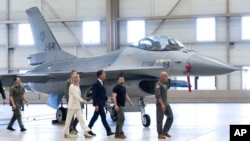 El presidente de Ucrania, Volodymyr Zelenskyy, segundo a la derecha, y el primer ministro interino neerlandés, Mark Rutte, en el centro, observan los aviones de combate F-16 en Eindhoven, Países Bajos, el 20 de agosto de 2023.