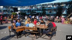 Los palestinos se refugian en una escuela administrada por la ONU de los ataques israelíes en curso en la Franja de Gaza en el campo de refugiados de Nuiserat, el sábado 14 de octubre de 2023.