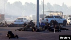 La gente se pone a cubierto, tras el anuncio de un ataque con misiles rusos hacia Kharkiv, en el lugar de un centro comercial de artículos para el hogar que fue alcanzado por un ataque aéreo ruso en Kharkiv, Ucrania, el 25 de mayo de 2024.. 