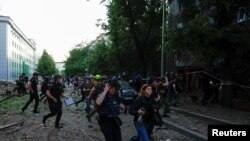 La gente corre a refugiarse, tras el anuncio de un ataque con misiles rusos hacia Kharkiv, en el lugar de un edificio de oficinas que fue alcanzado por un ataque aéreo ruso, el 25 de mayo de 2024.