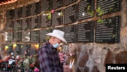 Un hombre coloca velas en un memorial durante una ceremonia para conmemorar el 40 aniversario de la masacre de El Mozote, en el pueblo del Mozote, en Meanguera, El Salvador, el 11 de diciembre de 2021.