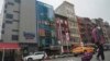 ARCHIVO – Se cree que un edificio de seis pisos con fachada de vidrio, en la foto, segundo desde la izquierda, en el barrio chino de Nueva York, opera un puesto de avanzada de la policía extranjera para China.