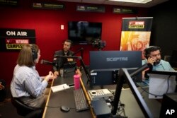 De izquierda a derecha, la invitada Carolina Rodríguez-Greer con el presentador de Mi Familia Vota, Osvaldo Franco, y el ingeniero Daniel Orona transmiten desde el estudio Phoenix de La Campesina, una cadena de radio en español, el 20 de marzo de 2024.