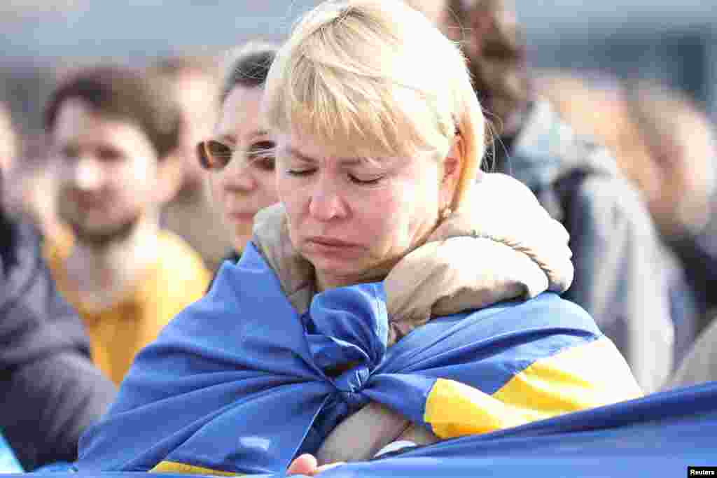 Una mujer envuelta en la bandera ucraniana llora durante una manifestación para conmemorar el primer aniversario de la invasión rusa de Ucrania, en Belgrado, Serbia, 24 de febrero de 2023.