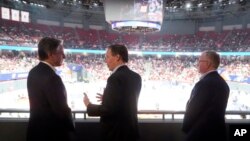 El secretario de Estado de EEUU, Antony Blinken, conversa con el embajador de EEUU en China, Nicholas Burns (centro) y el cónsul general en Shanghai Scott Walker en un partido de baloncesto entre los Shanghai Sharks y los Zhejiang G. B. en Shanghai, el 24 de abril de 2024.