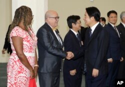 El vicepresidente de Taiwán, William Lai, a la derecha, le da la mano al encargado de negocios Carlos Pintos de Paraguay antes de partir hacia Paraguay en el Aeropuerto Internacional de Taoyuan en Taoyuan, Taiwán, el sábado 12 de agosto de 2023. (Foto AP/Chiang Ying-ying )