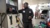 Un homme fait le plein d'essence dans une voiture dans une station-service à Nairobi, le 17 mai 2023.