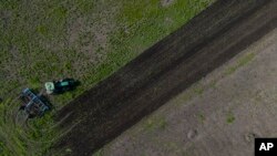 Un tractor cosecha un campo en Potomkyne, región de Kherson, Ucrania, 25 de abril de 2023.