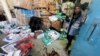 A Palestinian worker stands next to boxes of aid stained with blood, at an UNRWA aid distribution center following an Israeli strike, as the conflict between Israel and Hamas continues, in Rafah, in the southern Gaza Strip, March 13, 2024.