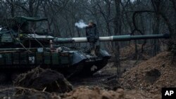 Un militar ucraniano fuma un cigarrillo sobre un tanque cerca de Bakhmut, Ucrania, el 8 de marzo de 2023.