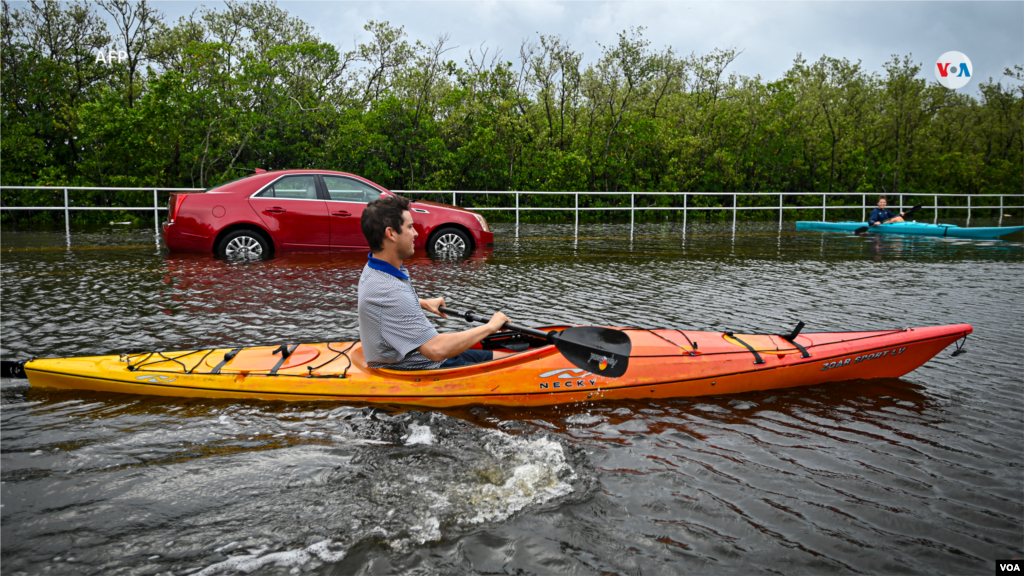 Algunas personas utilizan kayaks para viajar por una carretera inundada en Tampa, Florida.