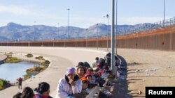 Migrantes de Venezuela, sujetos al Título 42 y dudosos de pasar a EEUU, esperan junto a personas de otras nacionalidades que hacen fila para ser procesados por la Patrulla Fronteriza estadounidense en El Paso, Texas, el 4 de enero de 2023.