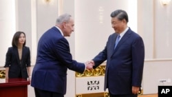 El líder de la mayoría en el Senado de EEUU, Chuck Schumer, saluda al presidente chino Xi Jinping antes de un encuentro bilateral en Beijing el 9 de octubre de 2023.