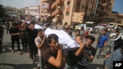Palestinos cargan cuerpos de la familia Abu Rayash muerta en bombardeos israelíes. En Rafah, Franja de Gaza, el 12 de octubre de 2023. [AP]