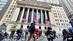 แฟ้มภาพ - ชายเดินผ่าน "Fearless Girl" ด้านหน้าตลาดหลักทรัพย์นิวยอร์ก เมื่อ 3 พ.ย. 2023 (เอพี)