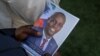 ARCHIVO - Una persona sostiene una fotografía del fallecido presidente haitiano Jovenel Moïse en la casa de su familia en Cabo Haitiano, Haití, el 23 de julio de 2021. Moïse fue asesinado ese mes en su residencia de Puerto Príncipe.