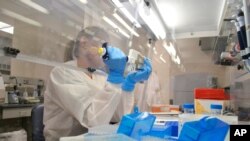 En esta foto de abri 12 de 2018, una laboratorista extrae ADN para un estudio de secuenciación genómica en el Laboratorio de Ciencia Molecular del Departamento de Salud Pública de Colorado, en Denver.
