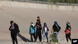 Un grupo de migrantes venezolanos camina hacia la frontera de Estados Unidos para entregarse a la patrulla fronteriza en Ciudad Juárez, México, el jueves 13 de octubre de 2022.