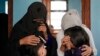 La familia de una joven de 19 años víctima de un atentado llora durante su funeral, en Kabul, Afganistán, el 30 de septiembre de 2022. El atacante detonó una bomba en una escuela mientras cientos de jóvenes afganas rendían sus exámenes de entrada a la universidad. 