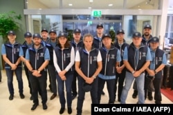 Esta imagen publicada el 29 de agosto de 2022 en la cuenta oficial de Twitter de la Agencia Internacional de Energía Atómica muestra al jefe de la OIEA, Rafael Grossi, posando con un equipo de 13 personas. (Foto AFP/ cuenta Twitter de @rafaelmgrossi)