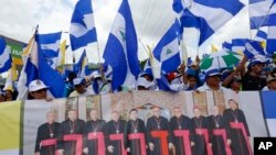 ARCHIVO - Manifestantes antigubernamentales sostienen una pancarta con un grupo de cardenales católicos, y una cita del papa Juan Pablo II en Managua, Nicaragua, el 28 de julio de 2018. 