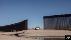 Un vehículo de la Oficina de Aduanas y Protección Fronteriza de Estados Unidos espera a un grupo de migrantes nicaragüenses mientras caminan desde Algodones, México, hacia la frontera sur estadounidense para entregarse a las autoridades y solicitar asilo,