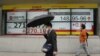 Personas caminan frente a monitores que muestran el índice Nikkei 225 de Japón, a la izquierda, y el tipo de cambio del yen japonés frente al dólar estadounidense en una firma de valores en Tokio, el lunes 24 de octubre de 2022.