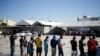 Migrantes de Haití, que regresaron al lado mexicano de la frontera para evitar la deportación, hacen cola para desayunar en un albergue del Instituto Nacional de Migración (INM) en Ciudad Acuña, México, el 25 de septiembre de 2021.