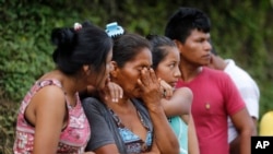 Madres angustiadas esperan en las afueras del cementerio en espera de sus seres queridos desaparecidos en Mocoa, Colombia.
