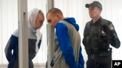 El sargento ruso Vadim Shishimarin escucha a su traductor durante una audiencia en la corte en Kiev, Ucrania, el 23 de mayo de 2022.