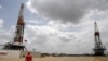 Un trabajador de un campo petrolero camina junto a las plataformas de perforación en un pozo petrolero operado por la petrolera estatal venezolana PDVSA, en la rica franja petrolera del Orinoco, el 16 de abril de 2015.