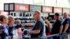 Los asistentes a la convención hacen fila para comprar productos de la marca NRA en la Tienda NRA, ubicada en el pasillo adyacente a la sala de exposiciones en la Reunión Anual de la NRA celebrada el 26 de mayo de 2022 en Houston.