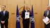 El embajador de Finlandia ante la OTAN, Klaus Korhonen, el secretario general de la OTAN, Jens Stoltenberg, y el embajador de Suecia ante la OTAN, Axel Wernhoff, conmemoran la solicitud de ingreso de Suecia y Finlandia, en Bruselas, Bélgica. (Johanna Geron/Pool via AP)