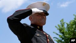 El Sargento del Cuerpo de Infantería de Marina de EEUU Tim Chambers saluda a los participantes en el evento "Rolling to Remember", durante el desfile anual de motocicletas, antes del Día de los Caídos, en Washington, el domingo 29 de mayo de 2022. 