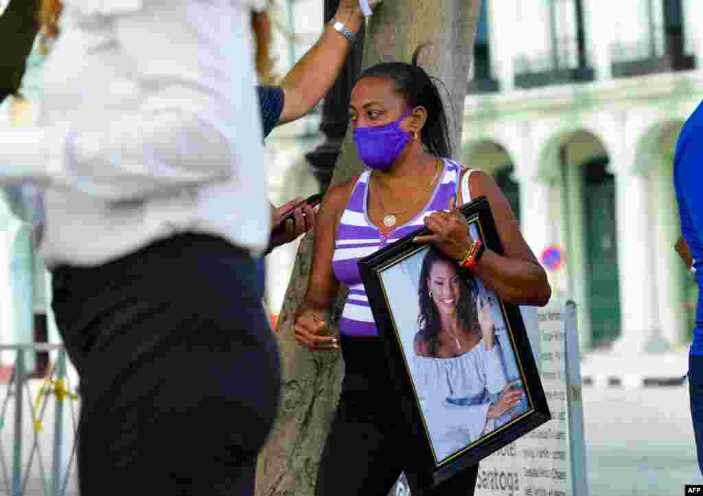 Un familiar de una víctima del accidente del Hotel Saratoga lleva una foto de su ser querido durante una vigilia en La Habana, el 13 de mayo de 2022.