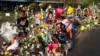 Aaliyah Banda, de 11 años, coloca un brazalete frente a la foto de Uziyah García, una de las víctimas del tiroteo en la escuela de la semana pasada, en un memorial en la Escuela Primaria Robb en Uvalde, Texas, el 31 de mayo de 2022.