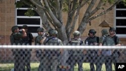 ARCHIVO - Agentes del orden están parados afuera de la Escuela Primaria Robb tras un tiroteo fatal el 24 de mayo del 2022 en Uvalde, Texas.