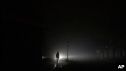 Una mujer camina por el centro de la ciudad que se quedó sin energía eléctrica después de un ataque con cohetes rusos en Kiev, Ucrania, el 24 de noviembre de 2022.
