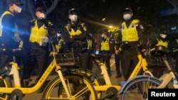 Los oficiales de policía montan guardia durante una manifestación contra las restricciones por COVID-19 luego del mortal incendio de Urumqi, en Shanghái, China, el 27 de noviembre de 2022.