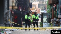 La policía hace guardia en la escena donde una estampida durante las festividades de Halloween mató e hirió a muchas personas en el popular distrito de Itaewon en Seúl, Corea del Sur, el 30 de octubre de 2022. (Yonhap/Reuters)